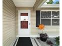 Inviting front entrance with a storm door and decorative landscaping at 1203 Zapata Pl, The Villages, FL 32159