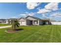 Well-manicured lawn with a charming single-story home and attached two-car garage at 12054 Ne 51St Cir, Oxford, FL 34484