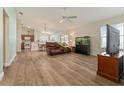 Spacious living room featuring hardwood floors, a ceiling fan, and a large window at 12054 Ne 51St Cir, Oxford, FL 34484