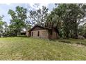 Brick home with lush green lawn and landscaping, offering a serene and private setting at 12196 Ne 4Th Pl, Oxford, FL 34484