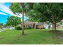 Well-maintained home featuring a manicured lawn, palm tree, and welcoming front exterior at 12846 Brown Bark Trl, Clermont, FL 34711