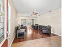 Spacious living room with hardwood floors, ceiling fan, and access to the porch via sliding glass doors at 14235 Se 85Th Ave, Summerfield, FL 34491