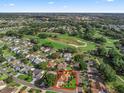 Aerial view of a charming home and neighborhood, near a golf course and lake, outlined in red at 1501 Lavaca Ln, The Villages, FL 32159