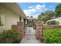 Inviting walkway with brick columns and wrought iron gate, enhanced by lush landscaping at 1512 S Pointe Dr, Leesburg, FL 34748
