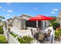 Enjoy outdoor living with a spacious patio including a dining set and an umbrella near the house and a pretty fountain at 1513 Lozano Ave, The Villages, FL 32159