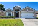 Charming single-story home featuring a well-manicured lawn and an attached two-car garage at 15501 Markham Dr, Clermont, FL 34714