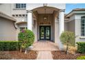Elegant home entrance featuring a brick walkway, stately columns, and lush landscaping at 2029 Stefano Ct, Mount Dora, FL 32757