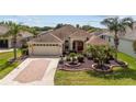 Beautiful single-Gathering home featuring mature landscaping, brick driveway, and a spacious two-car garage at 278 Matisse Ave, The Villages, FL 32162