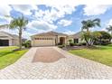 Well-maintained home boasts mature landscaping, a brick driveway, and a convenient two-car garage at 278 Matisse Ave, The Villages, FL 32162