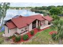 Stunning aerial view of a lakeside home, showcasing its red roof, mature landscaping, and serene waterfront setting at 3011 Lake Woodward Dr, Eustis, FL 32726