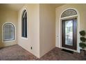 Inviting entryway with stylish glass door, brick pavers, arched windows and meticulously maintained landscaping at 38716 Oak Place Ct, Lady Lake, FL 32159