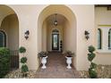 Elegant front porch with brick pavers, decorative planters, and arched entry leading to the front door at 38716 Oak Place Ct, Lady Lake, FL 32159