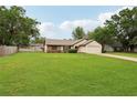 Inviting single-Gathering home with lush green lawn, mature trees, and a driveway leading to a two-car garage at 4145 Dora Wood Dr, Mount Dora, FL 32757