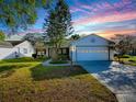 Charming single-story home featuring a manicured lawn and attached two-car garage at 507 Torres Pl, The Villages, FL 32159