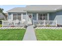 Inviting front porch with white picket fence, seating, and a well-maintained garden at 530 Valencia Pl, The Villages, FL 32159