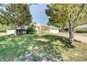 Charming home featuring a manicured front lawn, mature trees, and a welcoming facade at 605 Westview Dr, Minneola, FL 34715