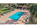 A relaxing outdoor community pool surrounded by lounge chairs and palm trees, offering a perfect spot for recreation at 623 Delgado Ave, The Villages, FL 32159