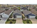 Aerial view showcasing the property's well-maintained landscaping, two-car garage and screened in porch at 6248 Siverson Ter, The Villages, FL 32163