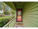 Cozy covered porch with a inviting red front door and cheerful decor, creating a warm welcome at 638 Mount Homer Rd # 3-C, Eustis, FL 32726