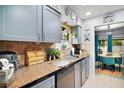 Well-lit kitchen featuring grey cabinets, granite countertops, tile backsplash and stainless steel appliances at 638 Mount Homer Rd # 3-C, Eustis, FL 32726