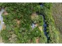 Aerial view of a home surrounded by lush greenery and a tranquil waterway at 7938 Jacksons River Rd, Leesburg, FL 34788