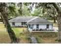 Charming single story home with a welcoming entrance and lush, mature landscaping adding to its curb appeal at 7938 Jacksons River Rd, Leesburg, FL 34788