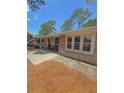 Low angle view of single story home with stone accents, patio, and manicured lawn at 802 Haselton St, Eustis, FL 32726