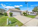 Well-kept single-story home with a two-car garage, lush lawn, and mature landscaping at 9081 Saint Andrews Way, Mount Dora, FL 32757