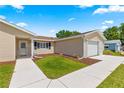 Inviting home entrance featuring a well-maintained lawn, mulch beds and a bright, clean walkway at 9645 Se 173Rd Pl, Summerfield, FL 34491