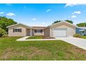 Well-kept home with lush lawn, beautiful landscaping, and an inviting driveway leading to the garage at 9645 Se 173Rd Pl, Summerfield, FL 34491