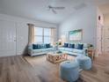 Bright living room featuring modern sofas, and an artistic beach painting, creating a relaxing ambiance at 1346 Kilgore Way, The Villages, FL 32163