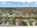 Beautiful aerial view of a neighborhood with a pond and well-maintained landscaping at 10021 Lake Miona Way, Oxford, FL 34484