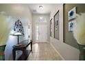 Elegant hallway with tile flooring and decorative accents, leading to a bright entryway at 10021 Lake Miona Way, Oxford, FL 34484