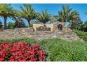 Stone monument sign for Esplanade at Wiregrass Ranch with lush landscaping and palm trees, welcoming residents and visitors at 1047 Timbervale Trl, Clermont, FL 34715