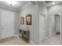 Inviting foyer with neutral walls, tile flooring, stylish console table, and artwork creating a welcoming atmosphere at 1047 Timbervale Trl, Clermont, FL 34715