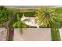 Aerial view showcasing a backyard patio with firepit and seating, surrounded by tropical landscaping at 1222 Camero Dr, The Villages, FL 32159