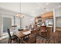 Open dining area featuring a wooden table with a chandelier and an adjacent modern kitchen at 1251 Saranac Pl, The Villages, FL 32163
