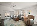 Bright living room featuring comfortable sofas, a ceiling fan, and sliding glass doors at 1251 Saranac Pl, The Villages, FL 32163