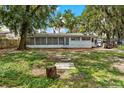 View of the back of the home with screened in porch and serene backyard at 1406 Spartan Ave, Leesburg, FL 34748