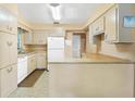 Functional kitchen featuring classic cabinets, white appliances, and a cozy breakfast bar at 1406 Spartan Ave, Leesburg, FL 34748