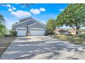 Charming two-story home featuring a three-car garage and a large driveway at 14305 Pine Cone Trl, Clermont, FL 34711