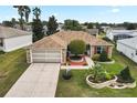 Inviting single-story home featuring brick accents, a well-kept lawn, and a long driveway leading to the garage at 1526 Blueberry Way, The Villages, FL 32162
