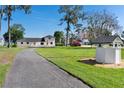 Expansive property featuring a well and immaculately manicured lawn, set against a backdrop of lush greenery at 16047 E Shirley Shores Rd, Tavares, FL 32778