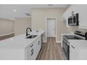Modern kitchen with white cabinets, quartz countertops, and stainless steel appliances at 16380 Se 83Rd Ct, Summerfield, FL 34491