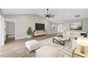 Bright living room featuring high ceilings, a ceiling fan, and sleek laminate floors at 16380 Se 83Rd Ct, Summerfield, FL 34491