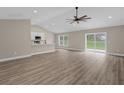 Open concept living space with laminate floors, a ceiling fan and sliding glass doors at 16380 Se 83Rd Ct, Summerfield, FL 34491