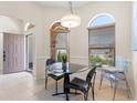 Bright breakfast nook featuring a glass table set and two arched windows at 1716 Bugle Ter, The Villages, FL 32162