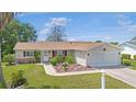 Charming single-story home with well-manicured lawn, garden, and attached two-car garage at 17806 Se 97Th Ct, Summerfield, FL 34491