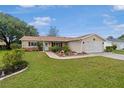 Inviting single-story home featuring red shutters, a well-kept lawn and a two-car garage at 17806 Se 97Th Ct, Summerfield, FL 34491