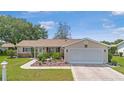 Well-maintained single-story home with a neatly landscaped front yard and a two-car garage at 17806 Se 97Th Ct, Summerfield, FL 34491